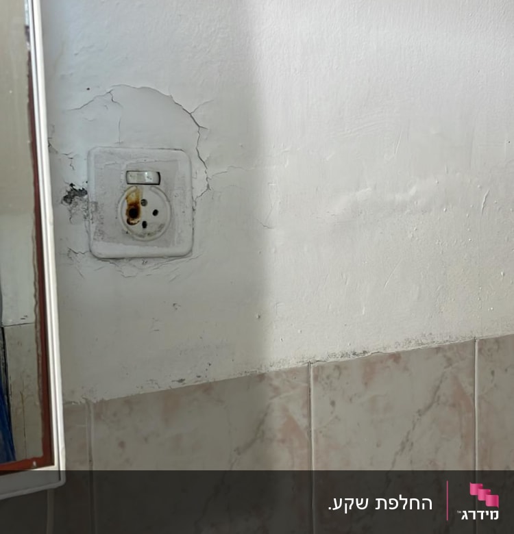 שקע חשמל עם סימני חלודה על הקיר